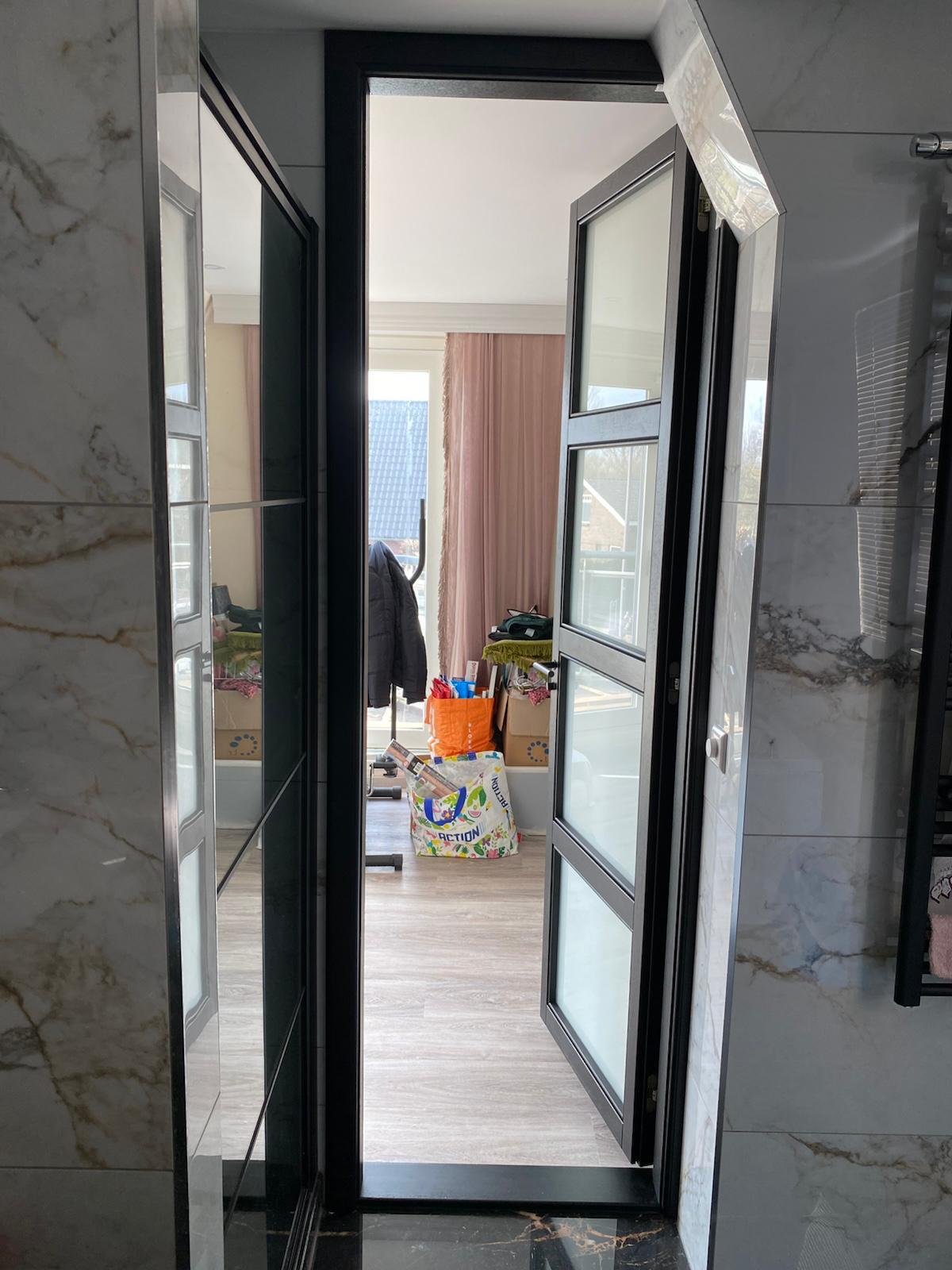 Moderne zwarte binnendeur met glaspanelen en strak kozijn